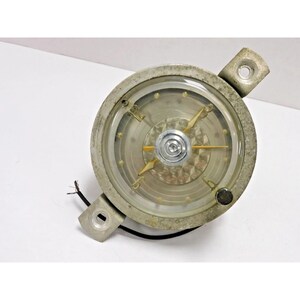 May include: A vintage round clock with a silver-colored bezel and a clear glass face. The clock face has a silver and gold-colored design with gold-colored hands. Two mounting tabs extend from the bezel. Black wires are attached.