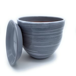 May include: A grey ceramic planter with a white swirl design and a matching lid. The planter is empty and ready for planting.