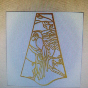 May include: A gold-colored metal cutout of a stylized bird with intricate details. The bird is facing left and has a long, pointed beak. The cutout is in the shape of a triangle.