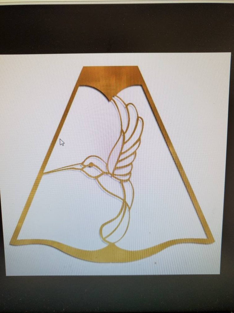 May include: A gold-colored metal hummingbird silhouette cut-out, with a decorative, wavy, scalloped edge.