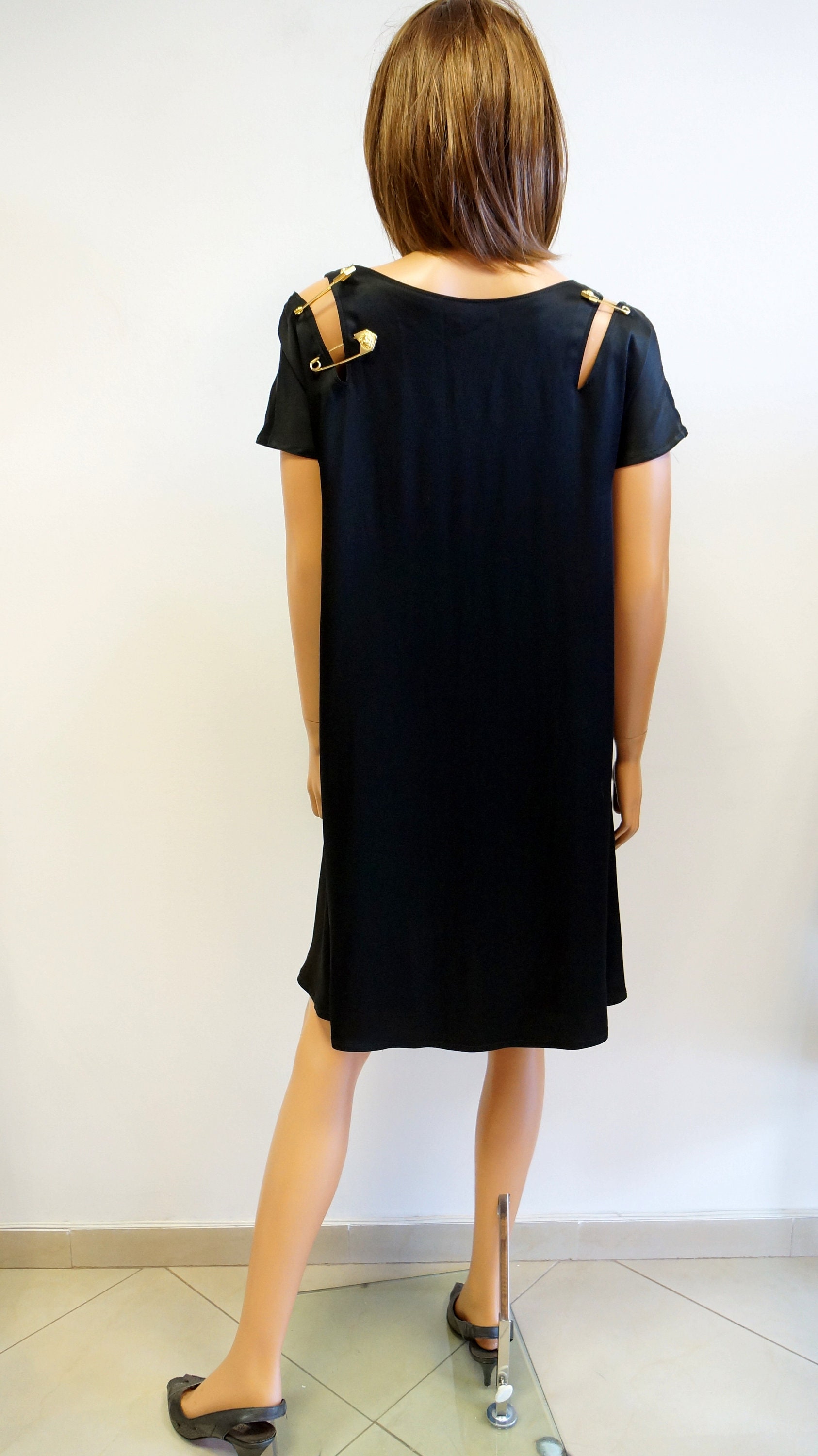 black versace dress with gold safety pins
