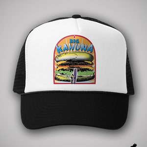 May include: White and black trucker hat with a colorful graphic of a large hamburger with the text "Big Kahuna" on it.