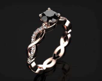 May include: A rose gold engagement ring with a black diamond center stone and smaller diamonds set in the band. The band is twisted and features a delicate design.