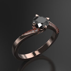 Può includere: Un anello di fidanzamento in oro rosa con un diamante nero centrale e diamanti più piccoli incastonati nella fascia.