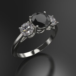 Pode incluir: Um anel de prata com uma grande pedra oval preta e duas pedras redondas brancas menores de cada lado.