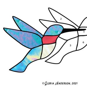 May include: A line drawing of a hummingbird with numbered sections for coloring. The hummingbird is in flight with its wings spread out. The drawing is on a white background. © Gloria Anderson, 2021