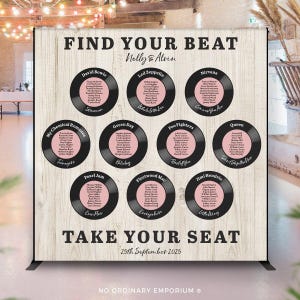May include: A wedding seating plan with a wooden effect background. It displays black vinyl record designs with pink centres, each listing names and song titles. Text at the top reads "FIND YOUR BEAT" and "TAKE YOUR SEAT". The date is 25th September 2025.