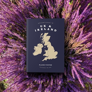 May include: A blue book with the title "Adventures in UK & Ireland" and a map of the United Kingdom and Ireland. The book has the text "Places Visited" and "Places to Go" on the bottom.