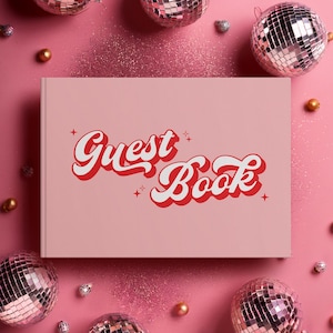 May include: A pale pink guest book with the words "Guest Book" in a red and white retro font. The book is surrounded by disco balls and decorative elements on a pink background.