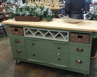 This recycled dresser- makes the perfect kitchen island-With a handy wine rack crafted right in front and matching baskets-and  slick design