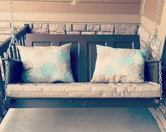 This mission style door works great for a porch swing, with a slightly angled back and cushions, and one heavy-duty hanging system.