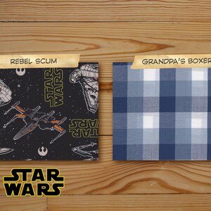 Puede incluir: Dos muestras de tela, una con fondo negro y un patr&oacute;n repetido de naves espaciales de Star Wars y el texto "STAR WARS", y la otra con un patr&oacute;n de cuadros azules y blancos. El texto "REBEL SCUM" est&aacute; sobre la tela de Star Wars y el texto "GRANDPA'S BOXERS" est&aacute; sobre la tela a cuadros.