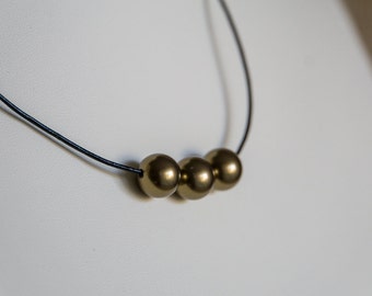 Gold Swarovski pearls on black leather necklace
