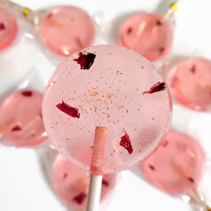 Pink lollipops with rose petals and edible glitter