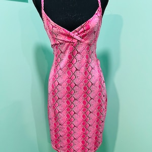 May include: A pink snakeskin print sleeveless dress with a V-neckline.