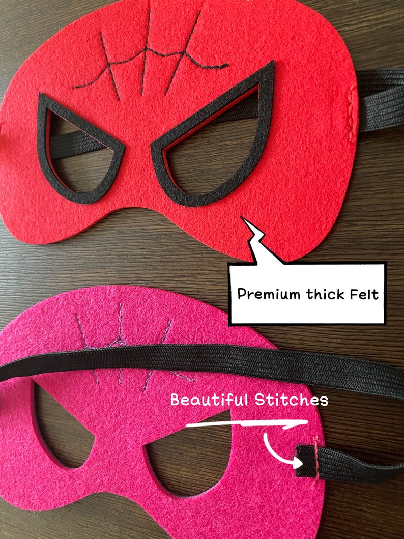 May include: Two felt superhero masks with black elastic straps. The red mask has a spider web design and the pink mask has a simple design. Both masks have black eye holes and are made with premium thick felt. The pink mask has the text "Beautiful Stitches" written on it.
