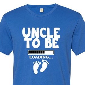 May include: A royal blue t-shirt with white text that reads "Uncle to Be" with a progress bar that says "Loading..." and two white baby footprints below.