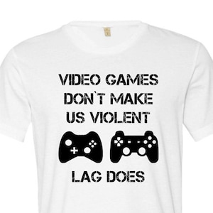 May include: White t-shirt with black text that reads "Video Games Don't Make Us Violent, Lag Does". The text is accompanied by two black video game controller icons.