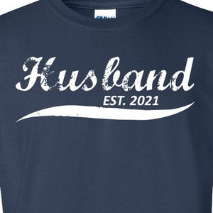 Könnte beinhalten: Marineblaues T-Shirt mit weißem Text, der "Husband Est. 2021" lautet.