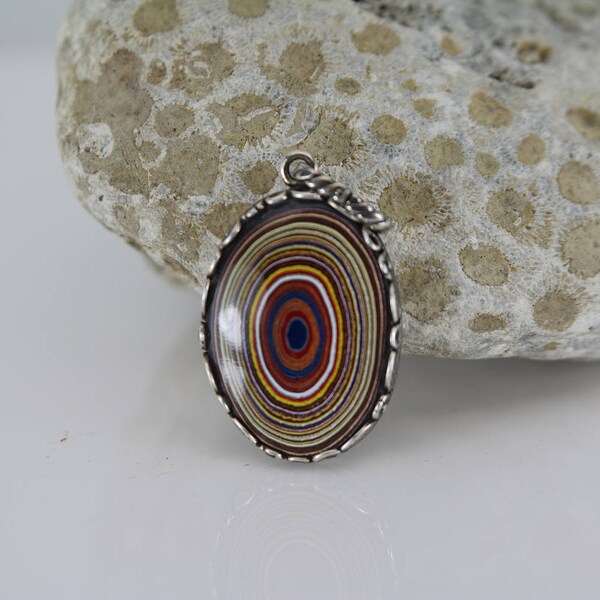 Fordite aussi connu comme moteur agate.  Ovale pendentif - taille est 18 mm x 26 mm.  Chaîne n’est pas inclus.   Belles rayures de plusieurs couleurs.