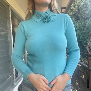 1960s robin&#39;s egg blue soft cotton sweater top with 3D crochet flower at neckline, long sleeves and fitted