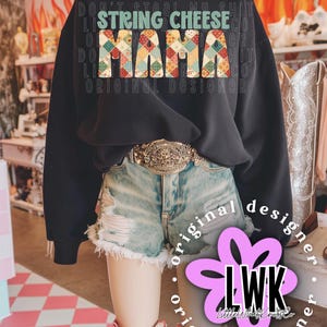 Könnte beinhalten: Schwarzes Sweatshirt mit dem Text "STRING CHEESE MAMA" in einem farbenfrohen Patchwork-Design. Das Sweatshirt wird mit Jeansshorts, einem Gürtel und Cowboystiefeln kombiniert. Über dem Haupttext steht der Schriftzug "DON'T STEAL MY SHIT".