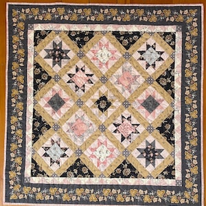 Peut inclure: Une couverture matelassée carrée avec un motif d'étoiles et de fleurs. Les couleurs dominantes sont le noir, le beige, le rose et le gris. La bordure est ornée d'un motif de vigne florale. Dimensions : environ 150 cm x 150 cm.