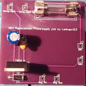 May include: A purple printed circuit board with various electronic components, including a fuse, a capacitor, a voltage regulator, a diode, and several switches. The board is labelled "NES Replacement Powersupply pcb by Lenkapo123".