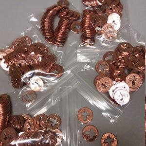 May include: Four bags of copper-colored metal coins with a cross design. The coins are in clear plastic bags with a zipper closure.