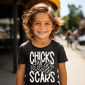 May include: A young person wearing a black t-shirt with white text that reads "CHICKS dig SCARS".
