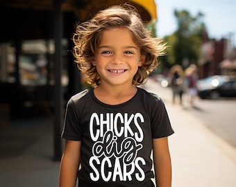 May include: A young person wearing a black t-shirt with white text that reads "CHICKS dig SCARS".