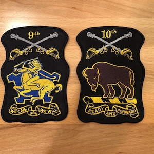 May include: Two black embroidered patches with gold and silver thread. The left patch features a yellow horse with a rider, a blue and yellow shield, and the text "9th" and "We Can We Will". The right patch features a brown buffalo, a yellow and black striped bar, and the text "10th" and "Ready And Forward".