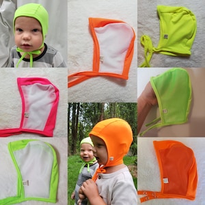 Puede incluir: Colección de gorros para bebés en varios colores brillantes, incluyendo verde neón, naranja y rosa. Los gorros tienen un panel frontal de malla y lazos debajo de la barbilla. Algunos gorros se muestran en bebés.