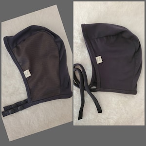 May include: A dark blue fabric sleep cap with a mesh panel and a white label that says "Sleep Cap". The cap has two ties and three buttons on the side.