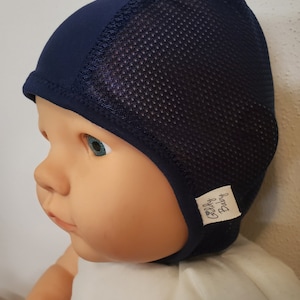 May include: A dark navy blue cap featuring a solid fabric front panel and a breathable mesh back panel. The cap includes a small white fabric tag on the side with the text Giddy Baby printed in black, and a solid navy blue trim along the bottom edge.