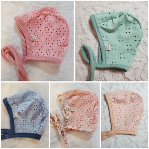 Puede incluir: Cinco gorros de bebé en varios colores: rosa, verde menta, azul claro, melocotón y estampado floral. Cada gorro presenta un delicado diseño de ojal y un ribete acanalado. Los gorros tienen lazos y algunos cierres a presión.