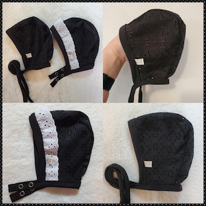 May include: Four black baby bonnets with white lace trim. The bonnets have a gathered top and tie at the back.