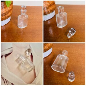 May include: Four clear glass bottles with stoppers. The bottles are of various sizes and shapes. The bottles are on a wooden surface.