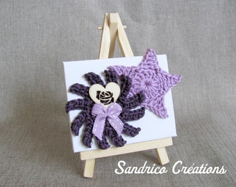 Décorations en crochet sur petite toile présentée sur mini chevalet étoile mauve soleil prune
