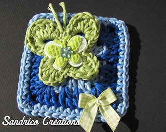 Butterfly-shaped brooch on a handmade square crochet in blue and green cotton