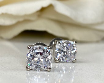May include: A pair of silver stud earrings with large, clear, square-shaped cubic zirconia stones.