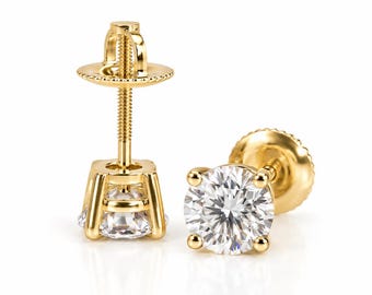 May include: A pair of yellow gold stud earrings featuring round brilliant-cut clear stones held in four-prong settings. Each earring includes a threaded post and a matching screw-back closure, showcasing the metallic gold finish and clear facets.