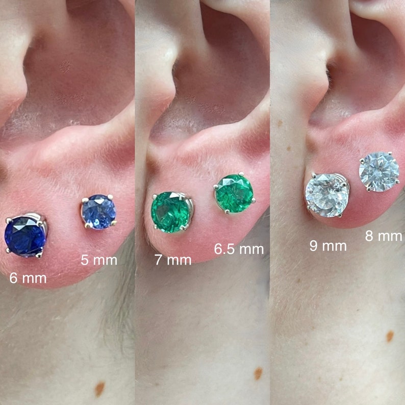 May include: Close-up of six different sizes of round stud earrings. The earrings are shown on a model's earlobe. The earrings are 6 mm, 5 mm, 7 mm, 6.5 mm, 9 mm, and 8 mm in diameter.