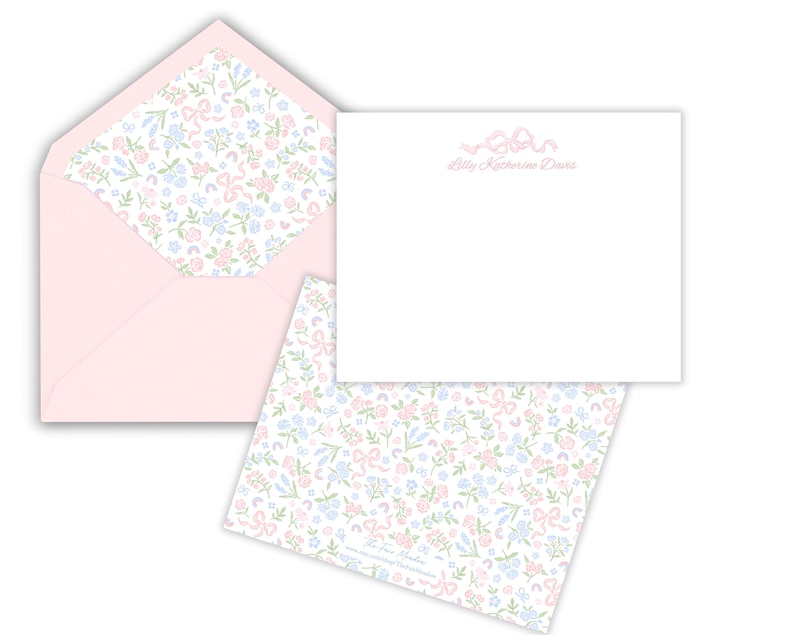 Baby thank you cards - white with dainty pink ribbon at the top and personalization under that in pink script. Back of card has floral bow pattern on the back.  Baby pink envelopes with floral pattern available for liner.