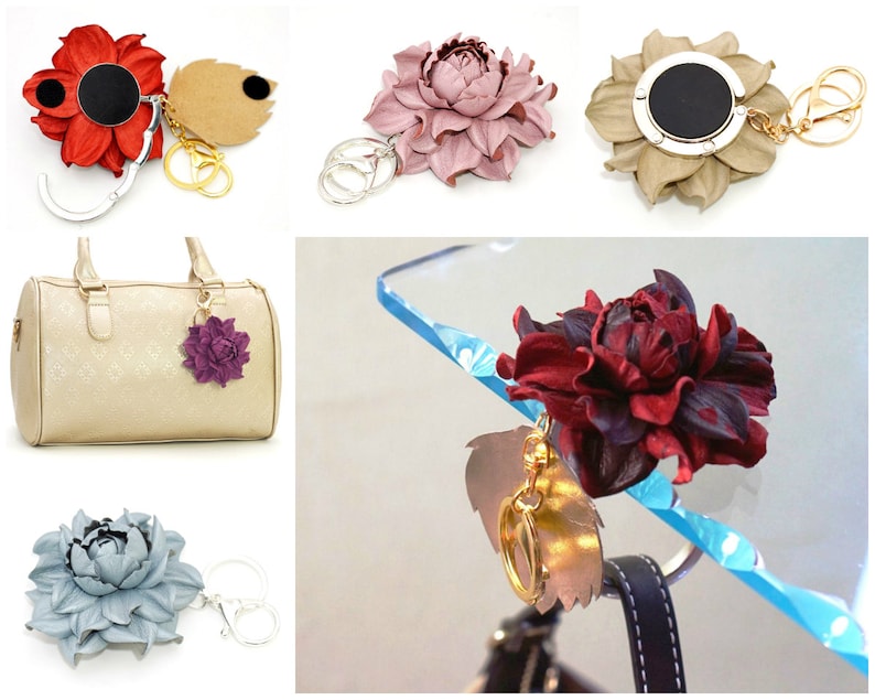 May include: A collection of leather flower-shaped keychains and bag charms in various colors, including red, pink, tan, purple, and blue. Some have metal clasps and key rings. One is attached to a beige handbag.