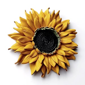 Puede incluir: Un gran girasol de cuero amarillo con un centro negro. El girasol est&aacute; hecho de p&eacute;talos de cuero individuales y tiene un aspecto realista.