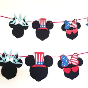 May include: A festive banner featuring black mouse silhouettes with patriotic designs. The banner includes stars, fireworks, Statue of Liberty crowns, Uncle Sam hats, and heart-shaped sunglasses with bows, all in red, white, and blue.
