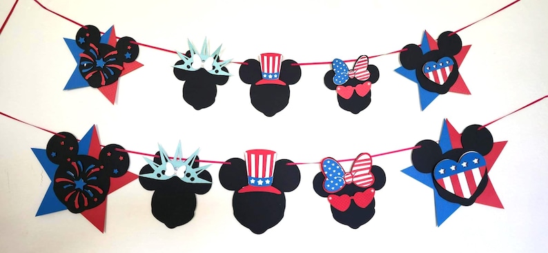 May include: A festive banner featuring black mouse silhouettes with patriotic designs. The banner includes stars, fireworks, Statue of Liberty crowns, Uncle Sam hats, and heart-shaped sunglasses with bows, all in red, white, and blue.