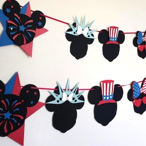 May include: A festive red string garland featuring patriotic Mickey Mouse-themed cutouts. The garland includes Mickey Mouse heads, stars, and other shapes in red, white, and blue, perfect for a themed party or celebration.