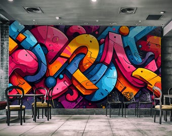 May include: A large wall mural featuring a vibrant graffiti design with bold, interlocking shapes in shades of bright pink, yellow, orange, and blue. The abstract composition includes curved lines, geometric forms, and dark outlines.